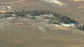 HD stock footage aerial video tilt from fields to reveal hills with snow and trees in Colorado Aerial Stock Footage | HDA13_330