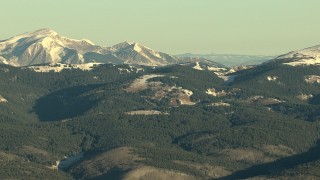 HD stock footage aerial video of Rocky Mountains with snow and evergreens at sunrise, Colorado Aerial Stock Footage | HDA13_422