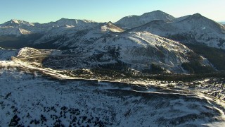 HD stock footage aerial video fly over a ridge and pan to a mountain road at sunrise, Rocky Mountains, Colorado Aerial Stock Footage | HDA13_444