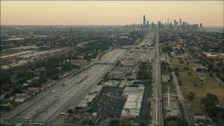 HD aerial stock footage follow freeway and rail through South Side at sunset toward Downtown Chicago, Illinois Aerial Stock Footage | PP001_020