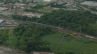 PP003_110 - HD stock footage aerial video of a passenger train passing industrial buildings in Wilmington, Delaware