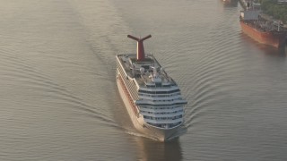 4K aerial stock footage of Carnival Cruise ship sailing Mississippi River, reveal Downtown New Orleans at sunrise, Louisiana Aerial Stock Footage | PVED01_012E