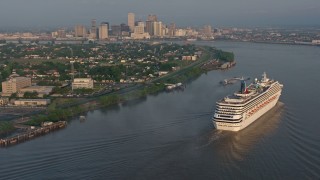 PVED01_014 - 4K aerial stock footage of a Carnival Cruise ship sailing the Mississippi River near Downtown New Orleans, Louisiana at sunrise