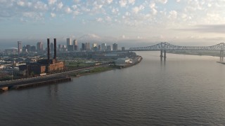 PVED01_019 - 4K aerial stock footage of Downtown New Orleans and Crescent City Connection seen from the river at sunrise, Louisiana