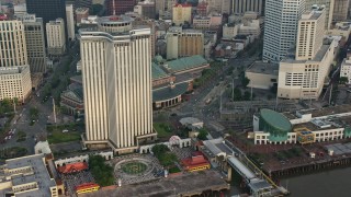 PVED01_051 - 4K aerial stock footage orbit Downtown New Orleans skyscraper to reveal Harrah's New Orleans Casino at sunrise, Louisiana