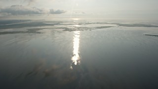 PVED01_063E - 4K aerial stock footage flying over the surface of a lake toward marshland in St. Bernard Parish at sunrise, Louisiana