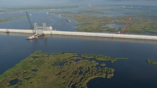 4K aerial stock footage pan across surge barrier and orbit a gate at sunrise in St. Bernard Parish bayou, Louisiana Aerial Stock Footage | PVED01_076