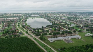 4K aerial stock footage orbit suburban homes around a small lake in New Orleans East at sunrise, Louisiana Aerial Stock Footage | PVED01_086