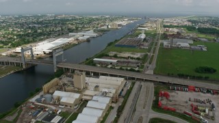 4K aerial stock footage flyby small bridge and factory buildings on the shore of Industrial Canal in New Orleans East, Louisiana Aerial Stock Footage | PVED01_168