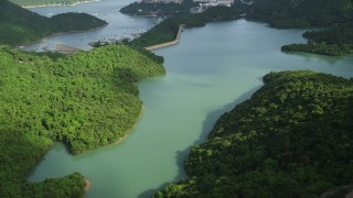 SS01_0064 - 5K stock footage aerial video fly over reservoir and tilt to reveal dam and apartment buildings by harbor on Hong Kong Island, China