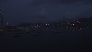 5K stock footage aerial video of Hong Kong Island skyline seen from cargo ships near the harbor at night, China Aerial Stock Footage | SS01_0125