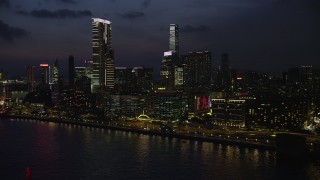 SS01_0162 - 5K stock footage aerial video flyby waterfront hotels with blinking lights near The Masterpiece tower at night in Kowloon, Hong Kong, China