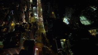 5K stock footage aerial video of following Nathan Road between office and apartment buildings at night in Kowloon, Hong Kong, China Aerial Stock Footage | SS01_0196