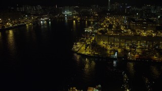 5K stock footage aerial video fly over ships docked under cranes at night at the Port of Hong Kong, China Aerial Stock Footage | SS01_0236