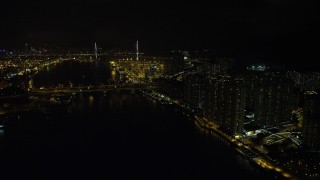 SS01_0259 - 5K stock footage aerial video follow Rambler Channel by Tsing Yi Island to approach Stonecutters Bridge at night, China