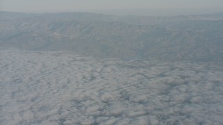 4K stock footage aerial video tilt from clouds to reveal and approach mountain range in Santa Clarita Valley, California Aerial Stock Footage | WA001_017