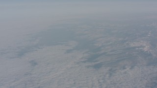 WA002_044 - 4K stock footage aerial video tilt up from a blanket of white clouds to reveal snow Sierra Nevada Mountain, California