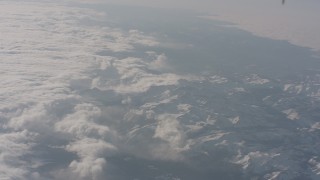 4K stock footage aerial video tilt and fly away from clouds over snowy Sierra Nevada Mountains, California Aerial Stock Footage | WA002_059