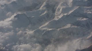 4K stock footage aerial video tilt and fly away from misty clouds over snowy Sierra Nevada Mountains, California Aerial Stock Footage | WA002_060