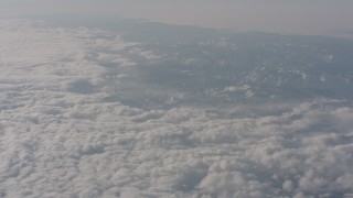 WA002_064 - 4K stock footage aerial video tilt from white clouds to reveal snowy Sierra Nevada Mountains, California