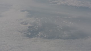 4K stock footage aerial video of reverse view of the Sierra Nevada Mountains surrounded by a layer of clouds, California Aerial Stock Footage | WA002_079