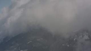 4K stock footage aerial video pan across clouds over snowy mountains, and approach a cloud bank in Washington Aerial Stock Footage | WA004_082