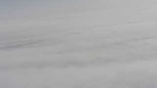 4K stock footage aerial video tilt from a bird's eye view of clouds to a wider view of the cloud cover over Oregon Aerial Stock Footage | WA004_101