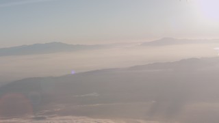 4K stock footage aerial video tilt from a bird's eye of clouds to reveal mountains at sunset in Southern California Aerial Stock Footage | WA005_013