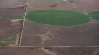 WA005_031 - 4K stock footage aerial video of a reverse view of flying through clouds to reveal circular crop fields in Kansas