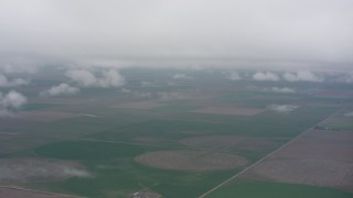 WA005_035 - 4K stock footage aerial video fly into the clouds above circular crop fields in Kansas