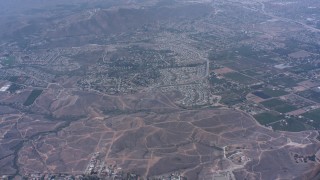 WA007_039 - 4K stock footage aerial video tilt from homes and fly over hills toward suburban neighborhoods, Riverside, California