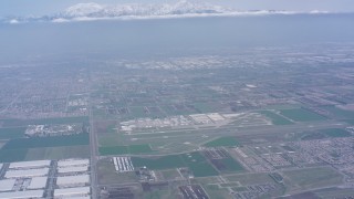 4K stock footage aerial video tilt from construction areas to reveal Chino Airport and snowy mountains, Chino, California Aerial Stock Footage | WA007_044