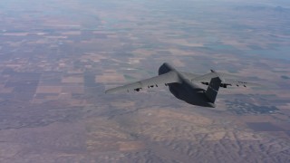 4K stock footage aerial video of tracking a Lockheed C-5 flying over hills near farmland in Northern California Aerial Stock Footage | WAAF01_C013_0117XK