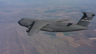 4K stock footage aerial video of flying beside a Lockheed C-5, pull back for wider view over Northern California Aerial Stock Footage | WAAF01_C021_0117TP