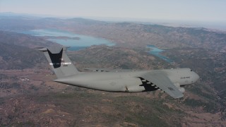 4K stock footage aerial video of a Lockheed C-5 flying over mountains near a lake, Northern California Aerial Stock Footage | WAAF01_C074_0117TM