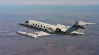 4K stock footage aerial video of revealing a Learjet C-21 as it descends into frame over farmland, Northern California Aerial Stock Footage | WAAF02_C010_011704