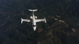 4K stock footage aerial video of panning across mountains to reveal a Learjet C-21 in Northern California Aerial Stock Footage | WAAF02_C019_0117JN_S003