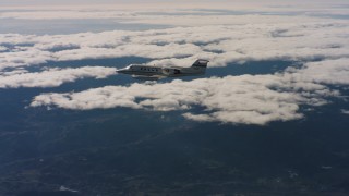 4K stock footage aerial video of a Learjet C-21 in flight near clouds and mountains in Northern California Aerial Stock Footage | WAAF02_C023_01171Q