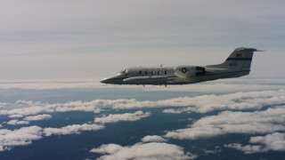 4K stock footage aerial video of Learjet C-21 flying over clouds, then pass around the tail of the plane in Northern California Aerial Stock Footage | WAAF02_C026_0117PB