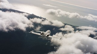 WAAF02_C029_0117CV_S002 - 4K stock footage aerial video of a Learjet C-21 weaving back and forth over clouds near the ocean in Northern California