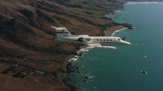 4K stock footage aerial video of a Learjet C-21 flying over the coast toward the ocean in Northern California Aerial Stock Footage | WAAF02_C033_0117PT