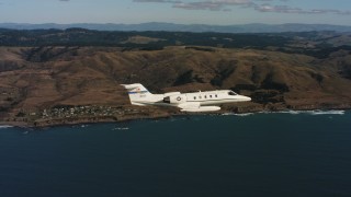 4K stock footage aerial video of a Learjet C-21 flying over the ocean near the coast in Northern California Aerial Stock Footage | WAAF02_C034_0117KG