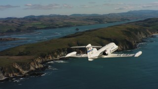 4K stock footage aerial video of a Learjet C-21 following the coast as it flies over the ocean in Northern California Aerial Stock Footage | WAAF02_C037_011796_S000