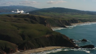 4K stock footage aerial video of revealing a Learjet C-21 flying along the coast in Northern California Aerial Stock Footage | WAAF02_C038_01173P