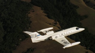 4K stock footage aerial video of a Learjet C-21 flying over mountains and out of frame in Northern California Aerial Stock Footage | WAAF02_C044_0117QQ