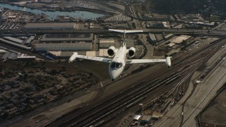 4K stock footage aerial video of a reverse view of a Learjet C-21 flying over industrial and residential areas in Northern California Aerial Stock Footage | WAAF02_C054_0117PF_S001