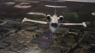 4K stock footage aerial video tilt from industrial buildings to reveal a Learjet C-21 in Northern California Aerial Stock Footage | WAAF02_C059_01174D_S000