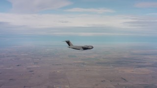 WAAF05_C006_0118HE - 4K stock footage aerial video of a Boeing C-17 flying over farmland in Northern California