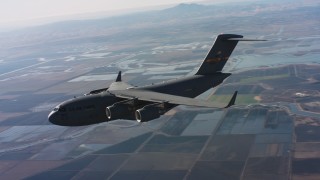 WAAF05_C013_01184S - 4K stock footage aerial video of a Boeing C-17 in flight over wetlands, Northern California