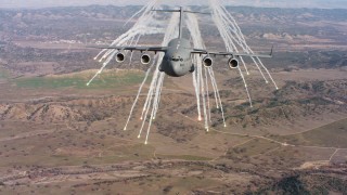 WAAF05_C033_0118KE - 4K stock footage aerial video of a Boeing C-17 shooting flares in Northern California